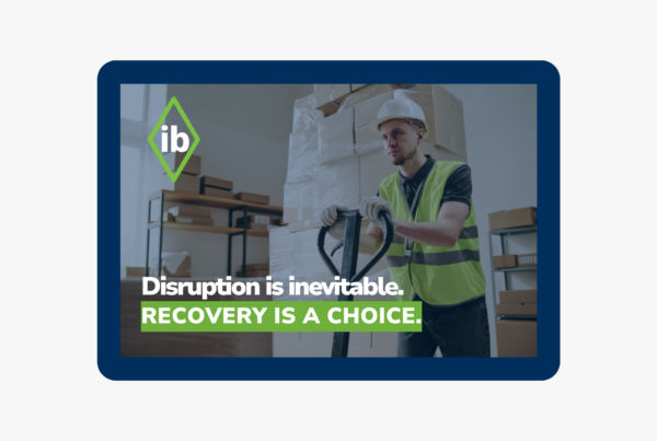 Logistics worker handling pallets in a warehouse with text “Disruption is inevitable. Recovery is a choice,” symbolizing resilient supply chain operations.